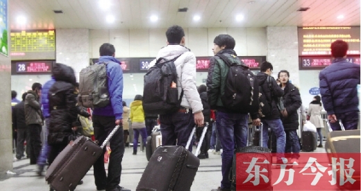 鄭州火車站東廣場(chǎng)售票大廳，幾名學(xué)生在售票窗口前躊躇