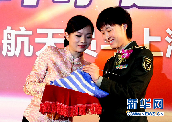 11月1日，航天員劉洋（右）在為“愛心”毛衣編織最后的收尾針。