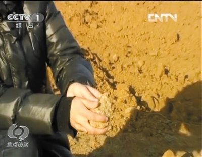 麻剛沙系麻剛石粉碎而成。記者找到一塊麻剛石，一捏就碎成粉末，硬度非常差。央視截圖