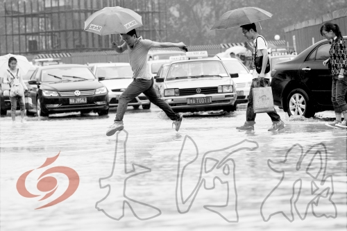 鄭州經(jīng)三路與北環(huán)交叉口處，積水較深，行人們不得不“練輕功”。 記者 白周峰 攝影