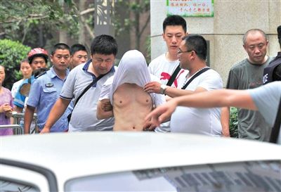 昨日，成都警方抓捕時(shí)與毒犯發(fā)生槍?xiě)?zhàn)。一名男犯罪嫌疑人被警方押出。