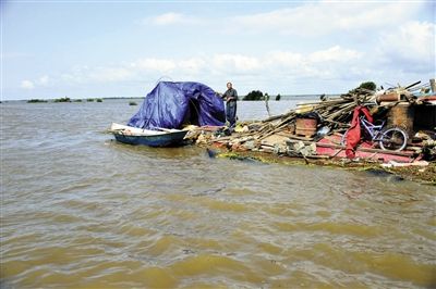 15日，因黑龍江水位上漲，一位轉移家中物資被困屋頂?shù)睦先讼蛎窬笾Ｐ氯A社發(fā)