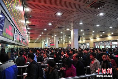 資料圖：12月25日，2014春運(yùn)臨客車票在廣州火車站開售，購(gòu)票市民在售票窗口前排起長(zhǎng)隊(duì)。中新社發(fā) 陳驥旻 攝