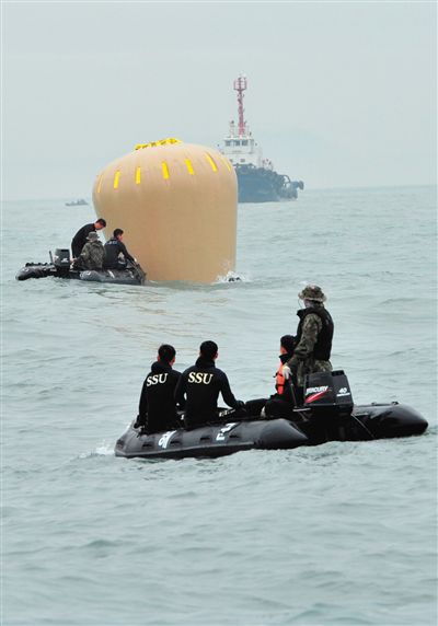 18日，搜救人員準備將氣囊捆綁到沉沒客輪上。
