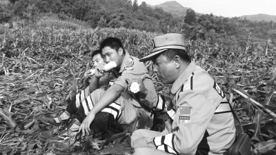 饑餓難忍，中國(guó)緊急救援河南基地的救援隊(duì)員在已毀的玉米地里撿拾生玉米吃。