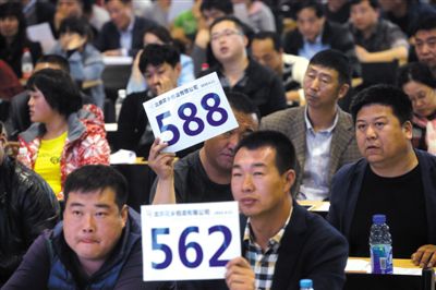 昨日，拍賣現(xiàn)場競拍者舉牌競拍。新京報記者