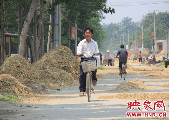 圖為王格現(xiàn)騎著自行車去學校。