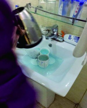 酒店服務員用潔廁液刷燒水壺和茶杯。