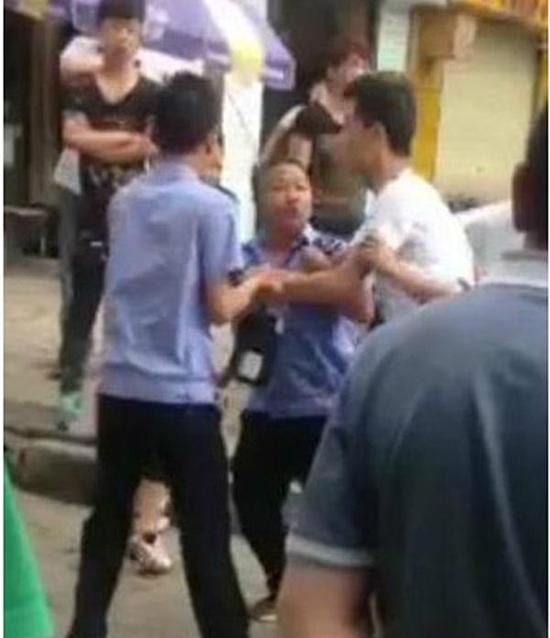付某（右）與城管執(zhí)法人員廝打在一起。