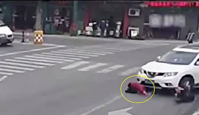 圖為小姑娘被卷進(jìn)車輪下瞬間。