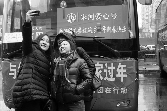 昨天上午8時(shí)，鄭州正道中環(huán)百貨廣場(chǎng)，準(zhǔn)備回家的老鄉(xiāng)在愛心大巴車前合影留念