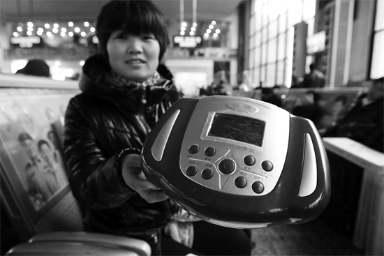 火車站候車室，李女士向記者展示她準(zhǔn)備孝敬父母的按摩儀