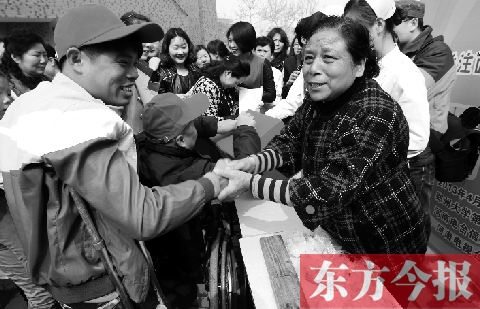 昨日，鄭大四附院的大樓前，“面人鄭”鄭玉芬（右）向前來(lái)捐款的殘疾人表示感謝