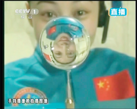 王亞平的倒影出現(xiàn)在水球中。新華社發(fā)（視頻截圖）