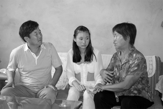 “商丘最美女兒”李丹（中）捐骨髓救母，愛心人士（左）送來(lái)1萬(wàn)元愛心款