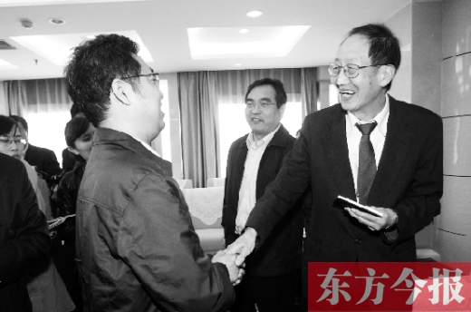 崔琦先生握手東方今報記者靳暉，感謝他把照片珍藏了15年