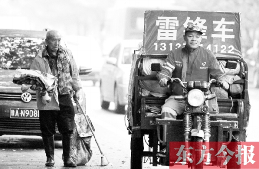 鄭州市商城路，一名環(huán)衛(wèi)工懷抱著剛剛收到的毯子，目送“雷鋒哥”孫德坤離開