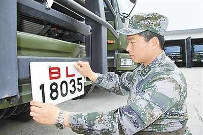 駐京某部上士高振超正在認(rèn)真更換新式軍車號牌。　　　本報(bào)記者　尹　航攝