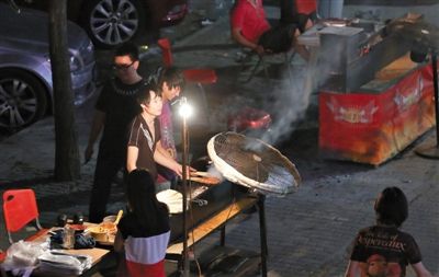 7月4日，青年路國(guó)美第一城小區(qū)附近的夜市臨街露天燒烤攤。