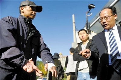 常林鋒在法院外展示雙手，他稱(chēng)被燙傷的手因刑訊逼供且未得到及時(shí)救治