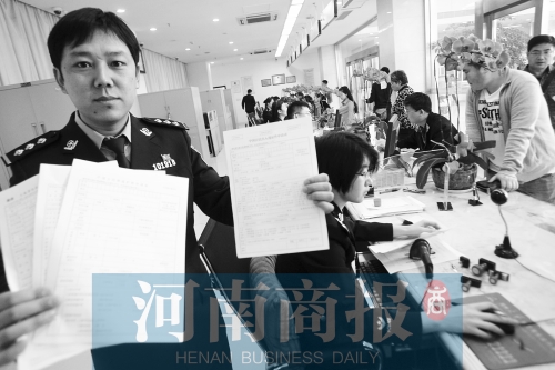 　民警左手拿的是新申請表，右手拿的是三份老申請表 王春勝/攝