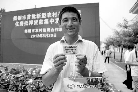 領(lǐng)到貸款，農(nóng)民開心地笑了。