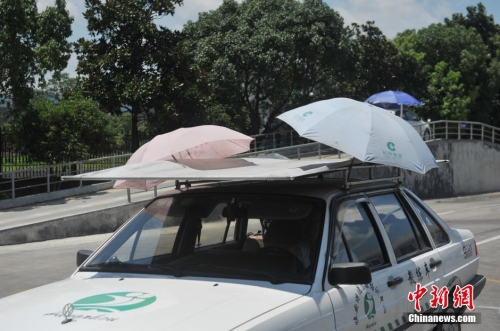 杭州一駕校現(xiàn)遮陽(yáng)新招 教練車(chē)車(chē)頂撐傘