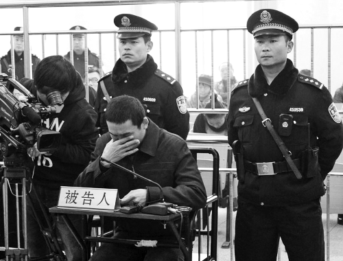 庭審中,29歲的李軍低著頭。