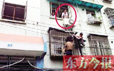 施救現(xiàn)場，劉鵬（圈內）先用繩子捆住老太確保安全 勞動報記者 郭娜 供圖