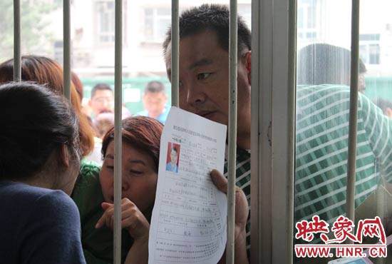 不少家長(zhǎng)擠在報(bào)名窗口前咨詢報(bào)名事宜。