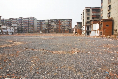 為降塵，旮旯王村拆遷后裸露的地面上鋪了一層石子。