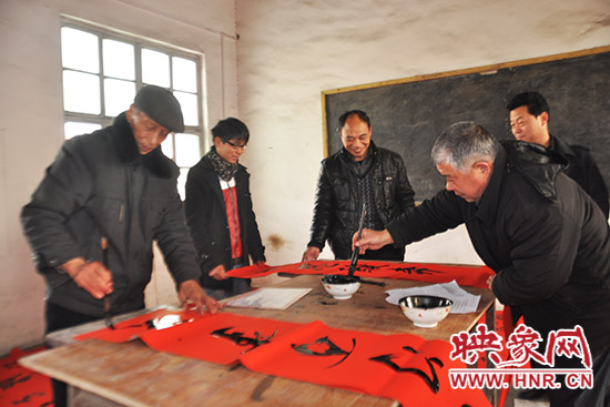 鞏義市魯莊鎮(zhèn)農(nóng)民書法愛好者正在寫春聯(lián)。