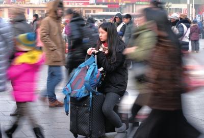 春運(yùn)首日，北京站客流量明顯增多，一名女孩在人流中等待進(jìn)站。
