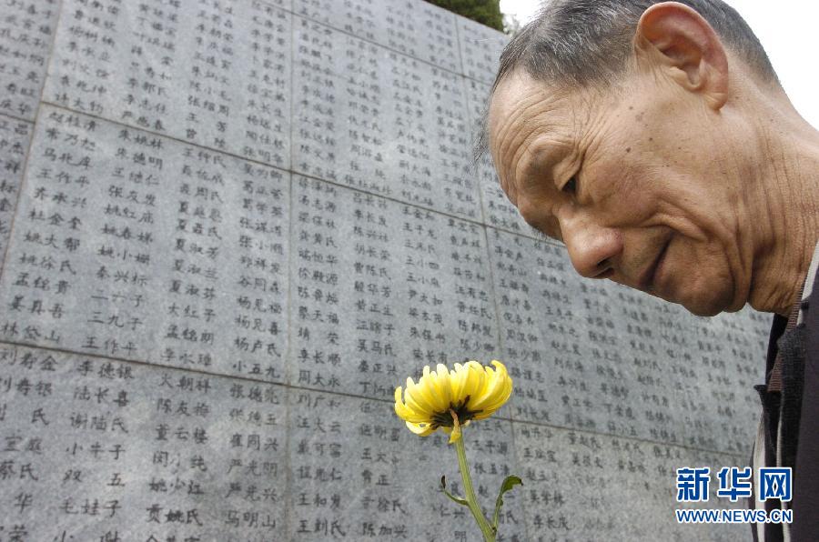2006年4月5日，74歲的南京大屠殺幸存者佘子清手捧鮮花，祭奠被日軍殺害的母親。