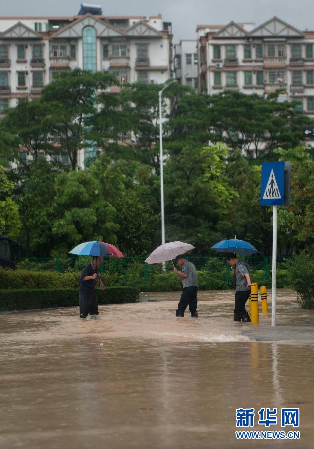 5月11日，人們在深圳西麗涉水行走。