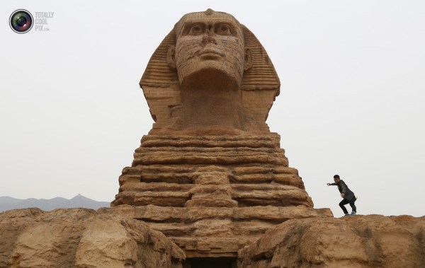 石家莊郊外，一名男子與山寨版獅身人面像合影留念。