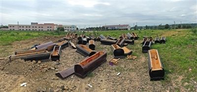 40多副棺木被砸壞后，扔在荒地上。