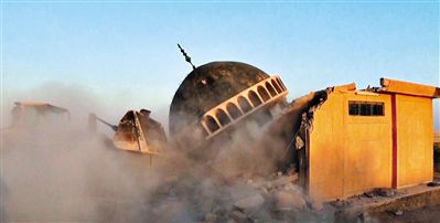 ISIS武裝人員駕駛推土機推倒一座清真寺的墻體。
