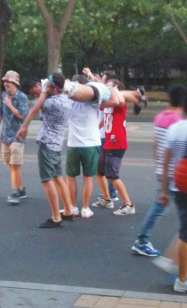 　四名外籍男子一同扛起醉漢拍照。