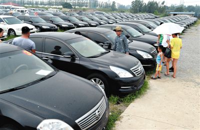 昨日，市民在山東棗莊一家拍賣公司場地上查看待拍賣公車。當日，棗莊市103輛公車公開拍賣。新華社記者