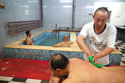 客人在搓澡。近日，百年歷史的鑫園浴池宣布將關(guān)張。新京報記者