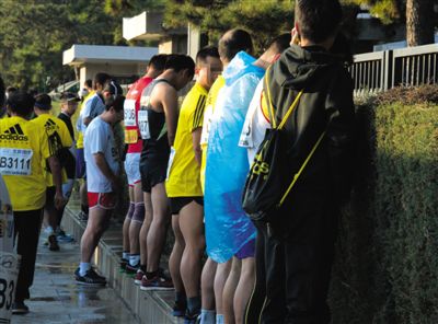 2013年10月20日，北京馬拉松比賽，由于廁位有限，一些選手在綠化帶“就地解決”。圖/IC