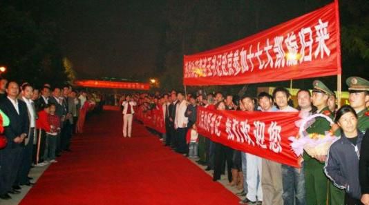 “夾道歡迎”中不少人打出橫幅，路上被鋪上了紅毯。