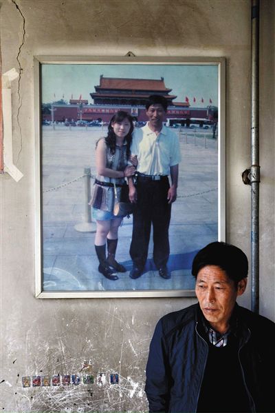 11月14日，承德市平泉縣，潘小梅父母的家，潘小梅父親靠在墻上，身后掛著數(shù)年前他和潘小梅在北京的合影照片。新京報記者