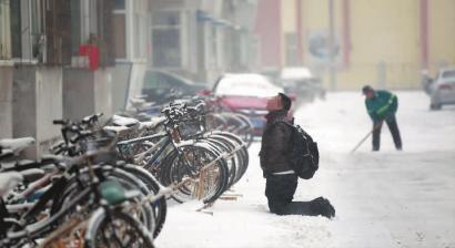 小伙子跪在樓前，一直抬頭看著樓上。 孫立國/攝