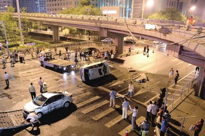路虎沖下國貿(mào)橋砸中一輛起亞轎車，橋上厚達幾十厘米的水泥護欄被撞斷，碎石四處散落，數(shù)十群眾在現(xiàn)場圍觀。
