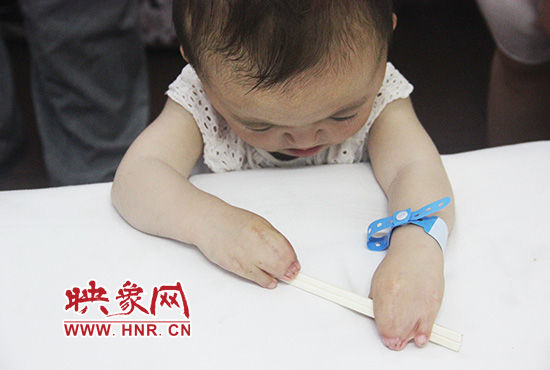 孩子握著筷子發(fā)呆。