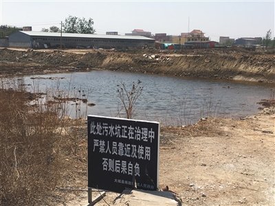 化肥廠滲坑的三分之一經(jīng)過治理，但水質(zhì)仍然呈黃褐色。