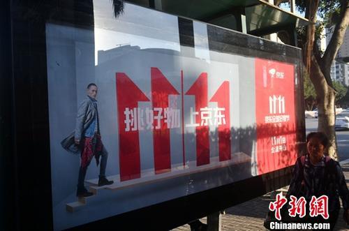 資料圖：11月1日，福州民眾從雙十一廣告牌前經(jīng)過。中新社記者 呂明 攝