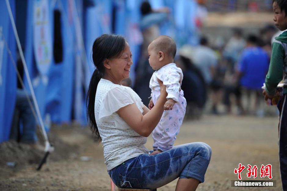 8月6日，一名年輕的母親在和孩子玩樂。